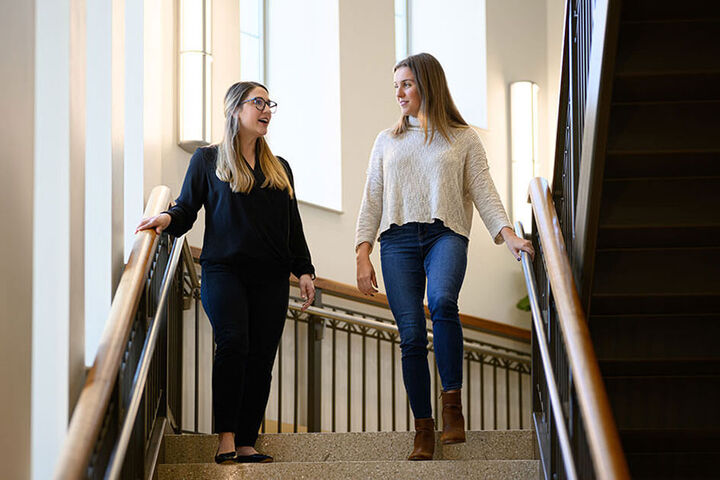 Two Kelley students walking down a stairway.
